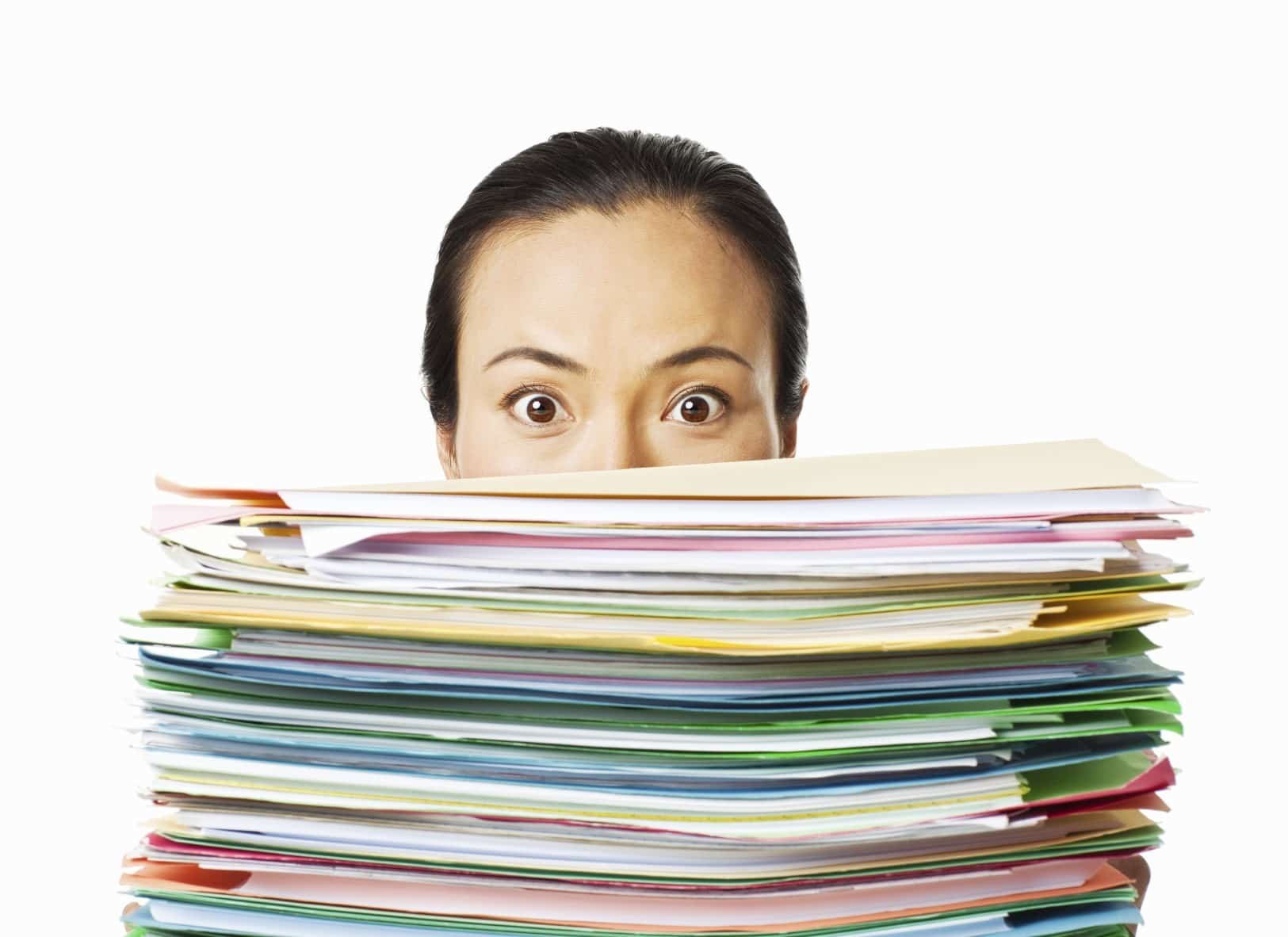 A closeup shot of a female holding files with only her eyes visible